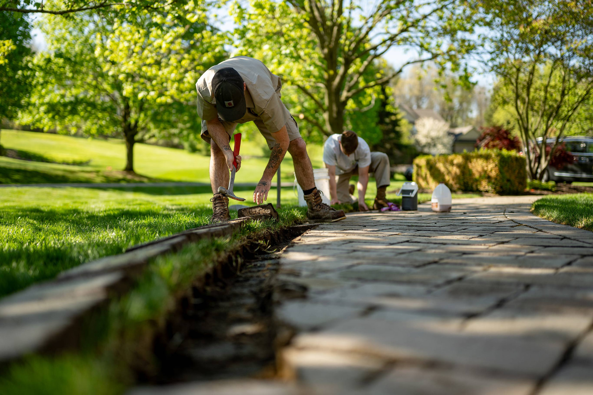 Low-angle view of paver walkway edging work on a Mid-Michigan property
