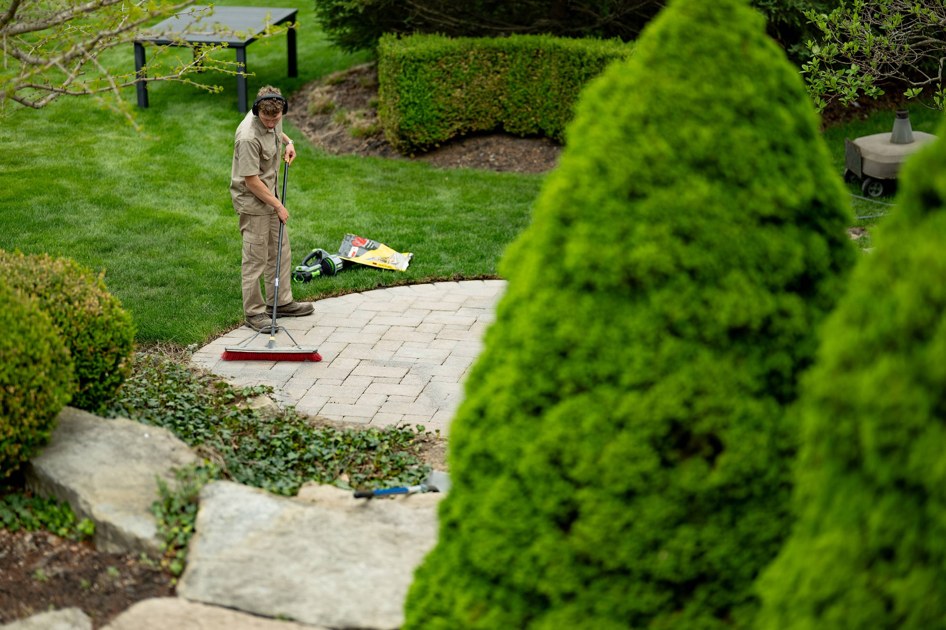Paver patio being swept clean after installation in Owosso, Michigan